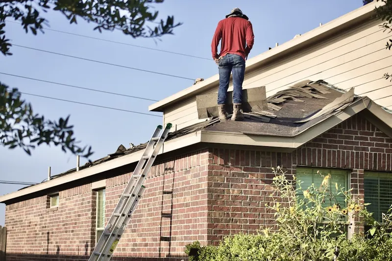 Professional roofer working on a residential roof in Sangerfield